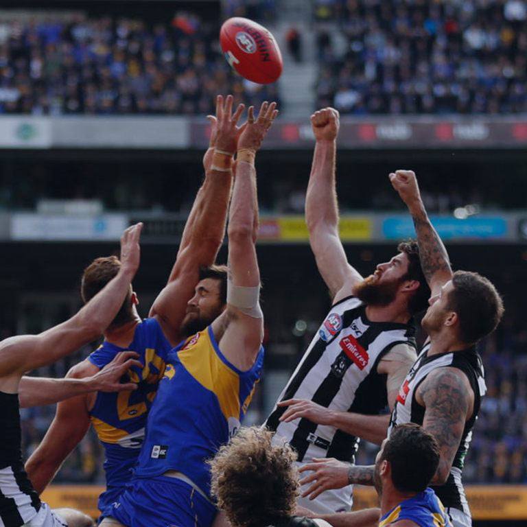 AFL mens players reaching to ball.